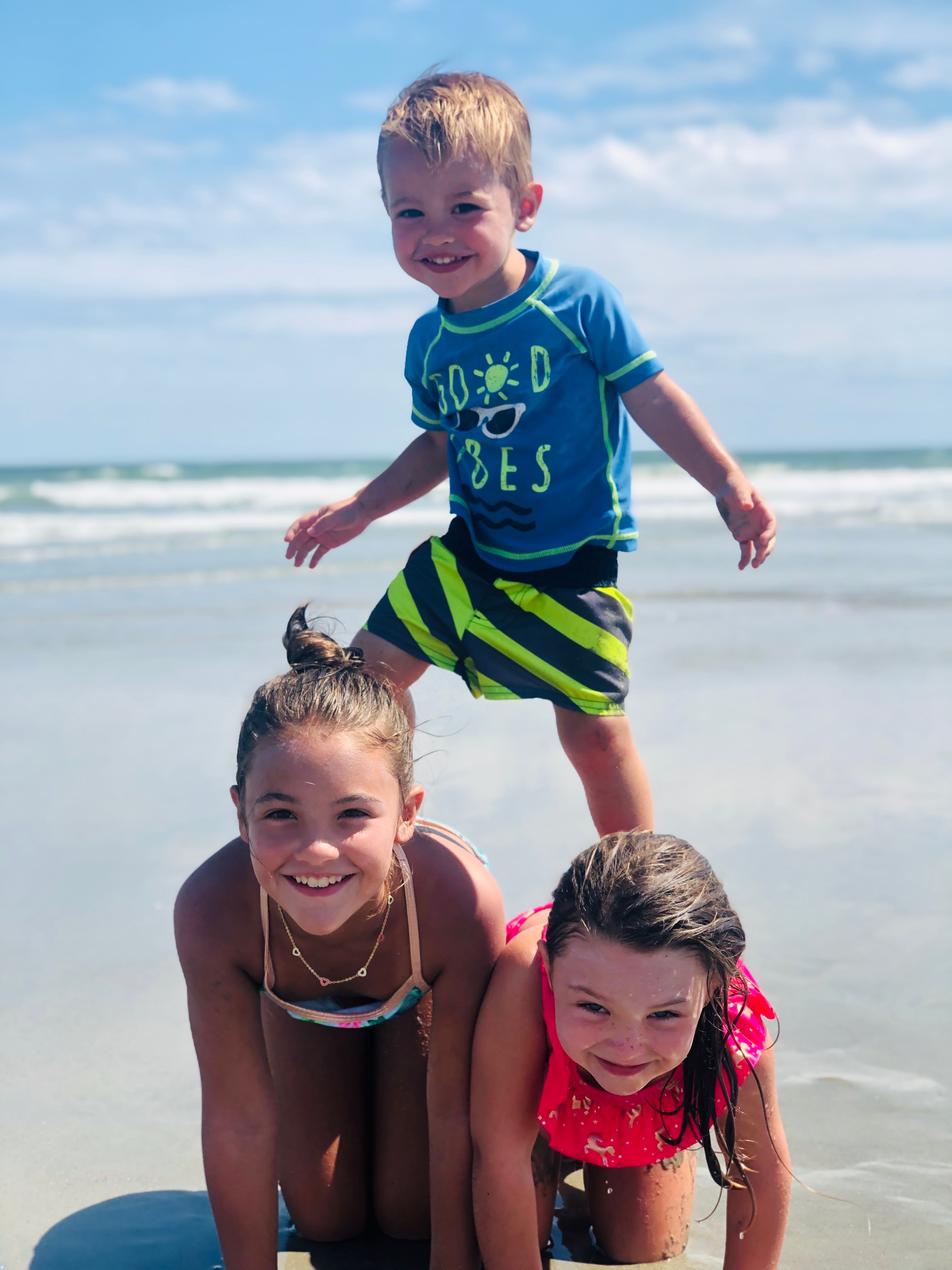 Little boy stepping on his sisters to make a pyramid