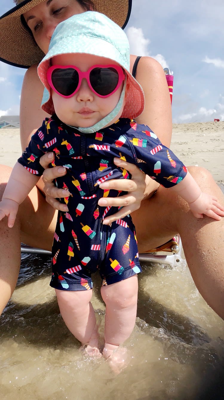 Little girl on the beach with her mom