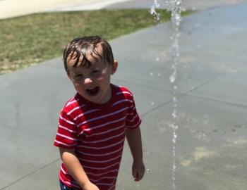 kid playing in holden beach splash pad